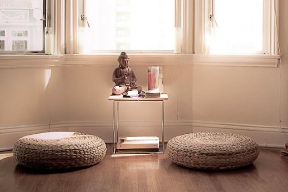 Una habitación con dos cojines y un pequeño mueble con figuras especiales pueden hacer un buen salón de meditación.